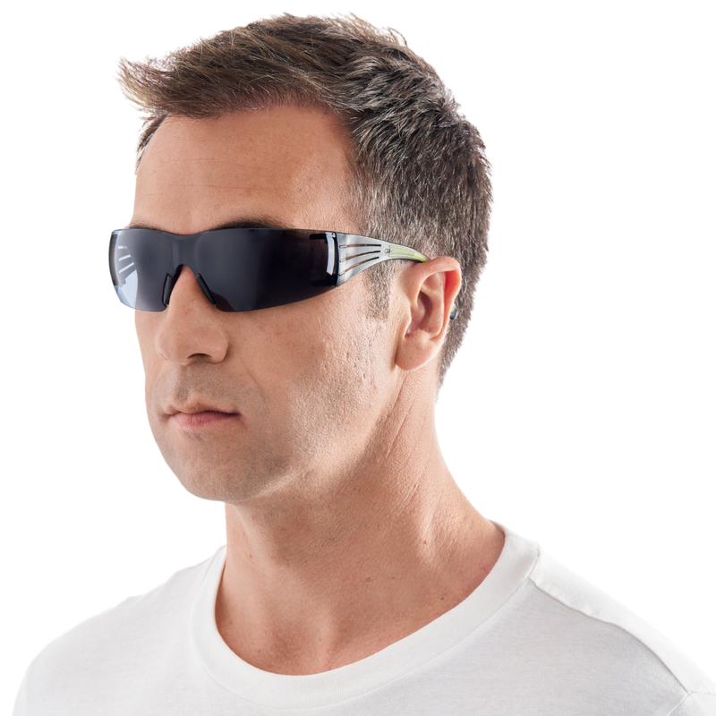 Ein Mann mit kurzen braunen Haaren modelliert die 3M™ SecureFit™ Schutzbrille 400 von 3M Deutschland GmbH. Er trägt eine schwarze Rundum-Schutzbrille und ein weißes T-Shirt vor einem schlichten weißen Hintergrund.
