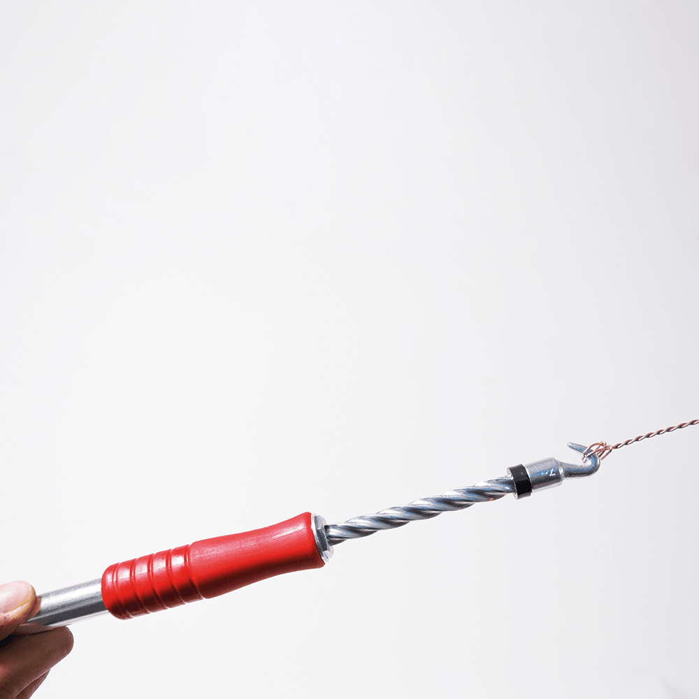 A hand holds the DEISS 6901 bag sealing device from EMIL DEISS KG (GmbH + Co.) with a red handle, twisted rod, and hook-shaped gripping wire - ideal for professional use and efficient sealing. On a solid white background. Package: 50 pieces.