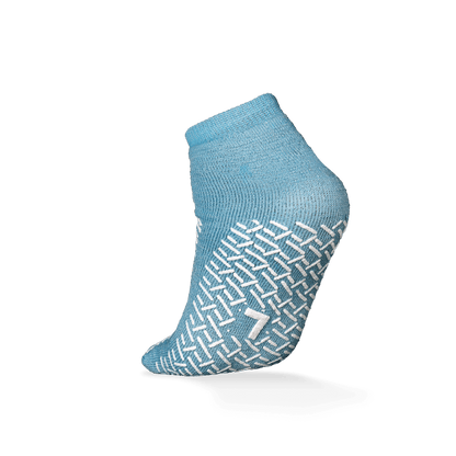Pictured is a single ECO-PLUS anti-slip disposable sock from AMPri Handelsgesellschaft mbH in light blue with a white anti-slip pattern and the number "7" on the sole, ideal for medical use, against a plain white background.