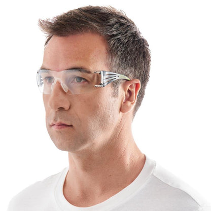 Ein Mann mit kurzen braunen Haaren trägt eine 3M™ SecureFit™ Schutzbrille 400 von 3M Deutschland GmbH und ein weißes T-Shirt mit Rundhalsausschnitt und blickt geradeaus vor einem weißen Hintergrund.