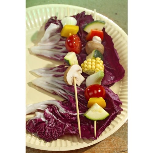 Zwei PAPSTAR 250 Schaschlikspieße, Bambus „pur“ der PAPSTAR GmbH werden mit Tomaten, Champignons, Zucchini, Mais, Zwiebeln und Paprika belegt und auf einem runden Teller angerichtet, der mit violetten Radicchioblättern ausgelegt ist.