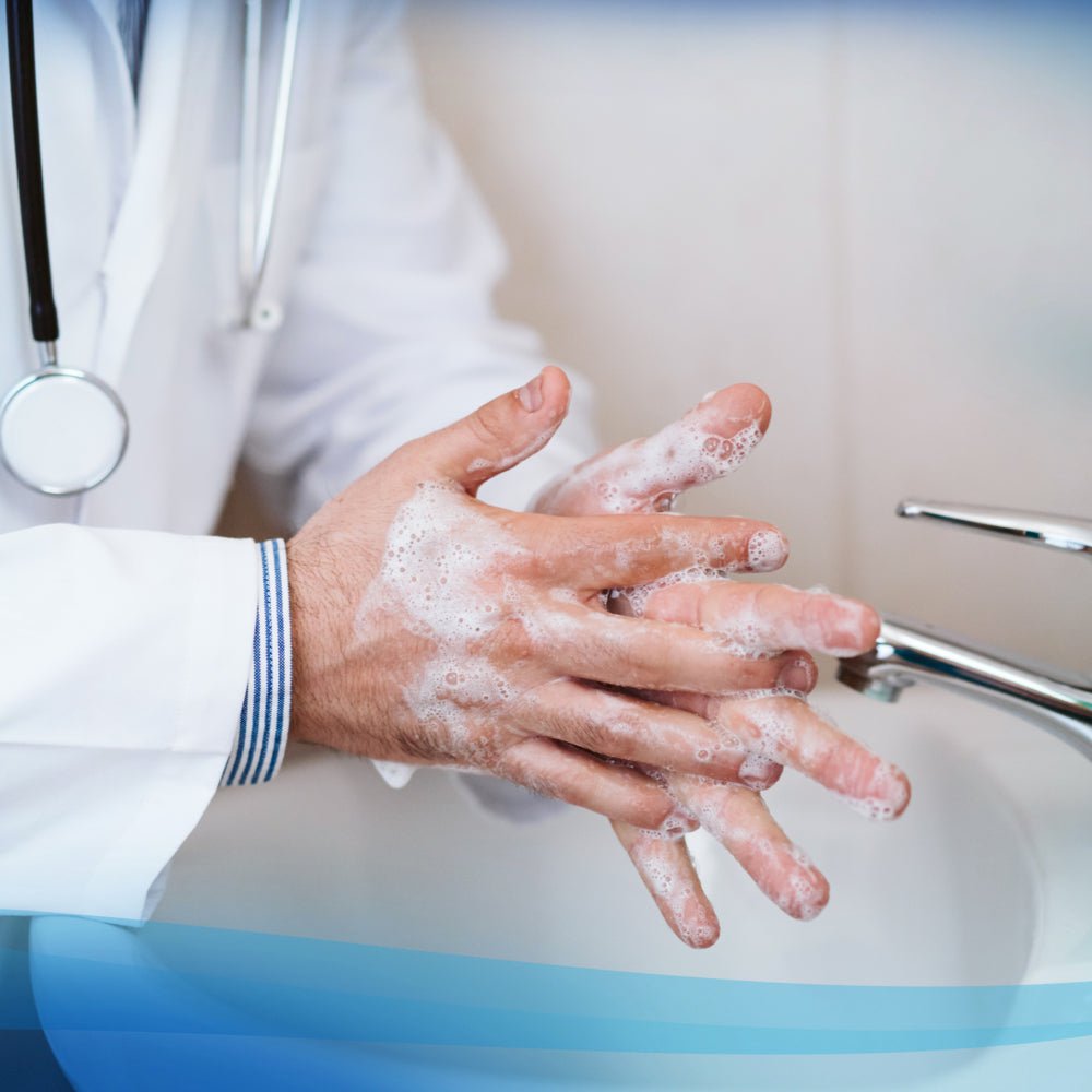 A person in a white lab coat uses Scott® Control™ Antibacterial Hand Cleanser from Kimberly-Clark GmbH at a sink, creating foam. A stethoscope around their neck underscores the necessity of hygienic hand cleaning in healthcare.