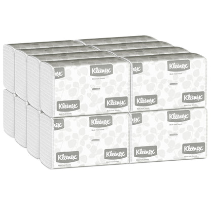 Ein Karton mit 16 Packungen Kleenex® Handtücher MultiFold Weiß, jeweils mit Kleenex-Logo und hellgrauem Muster, von Kimberly-Clark GmbH - ideal für Waschräume, die zuverlässige multifaltbare Handtücher benötigen (16 x 150 Blatt).