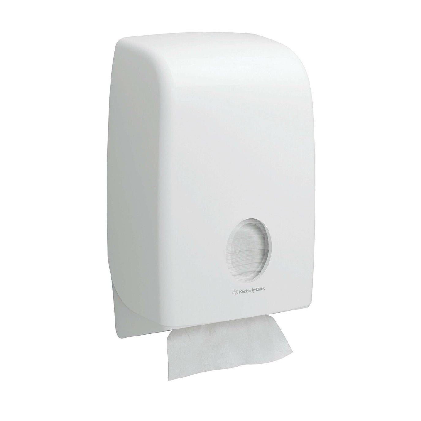 A white, wall-mounted Kimberly-Clark Scott® Essential™ hand towel dispenser with a round window shows interfold towels inside (White, Small, 15 clips x 340 sheets) and a towel partially dispensed for hygienic hand drying.