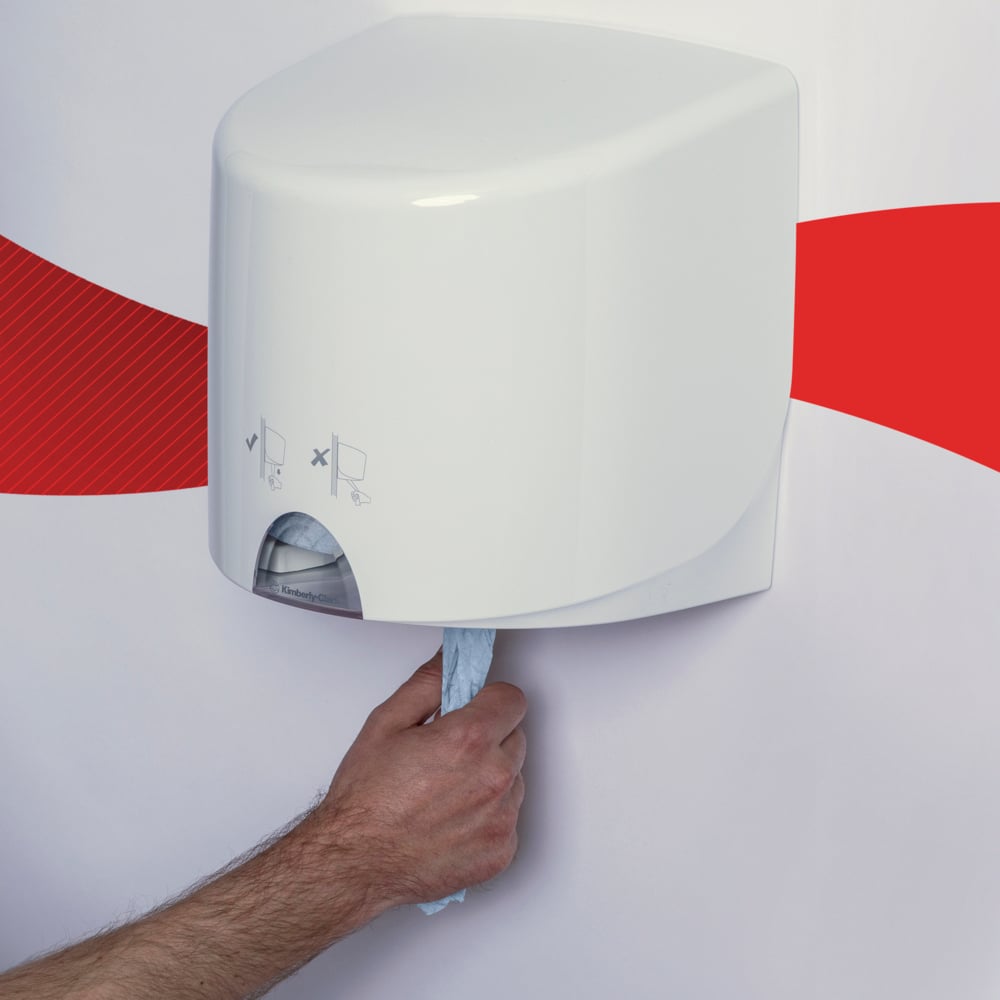 Eine Hand zieht ein blaues WypAll® L10 Papierwischtuch für Lebensmittel & Hygiene von Kimberly-Clark GmbH aus einem weißen Wandspender vor einer weißen Wand mit rotem Wellenstreifen.