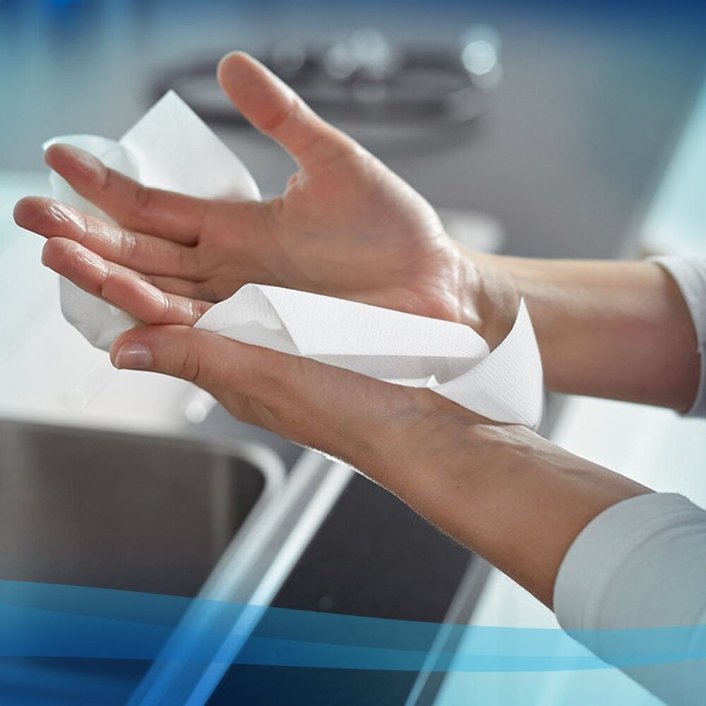 A person dries their hands with a Scott® Control™ towel (white, large, 15 clips x 240 sheets) from Kimberly-Clark GmbH over a sink; hands and towel are in focus against a slightly blurred countertop and sink.