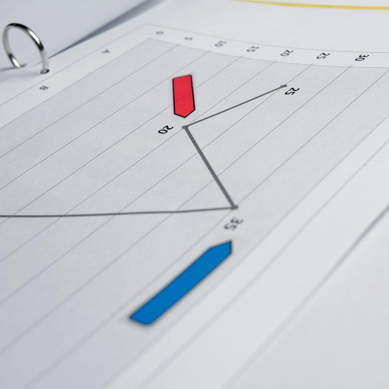 A close-up of a line chart in a folder with red and blue data points. 3M Deutschland GmbH Post-it® Index Arrows, Various Colors, 11.9 mm x 43.2 mm (100 sticky notes/dispenser) mark important document organizing sections.