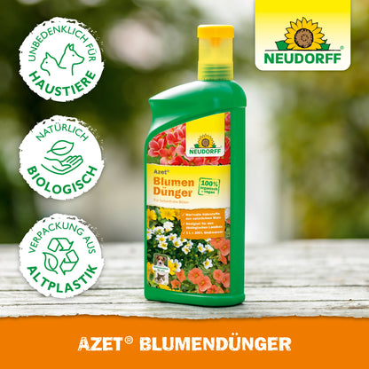 Eine grüne Flasche von Neudorff Shop Azet BlumenDünger flüssig steht auf Holz. Auf dem Etikett sind Blumen und Symbole abgebildet, die darauf hinweisen, dass dieser Flüssigdünger haustiersicher, natürlich und in einer Biokunststoffverpackung für gesundes Pflanzenwachstum ist.
