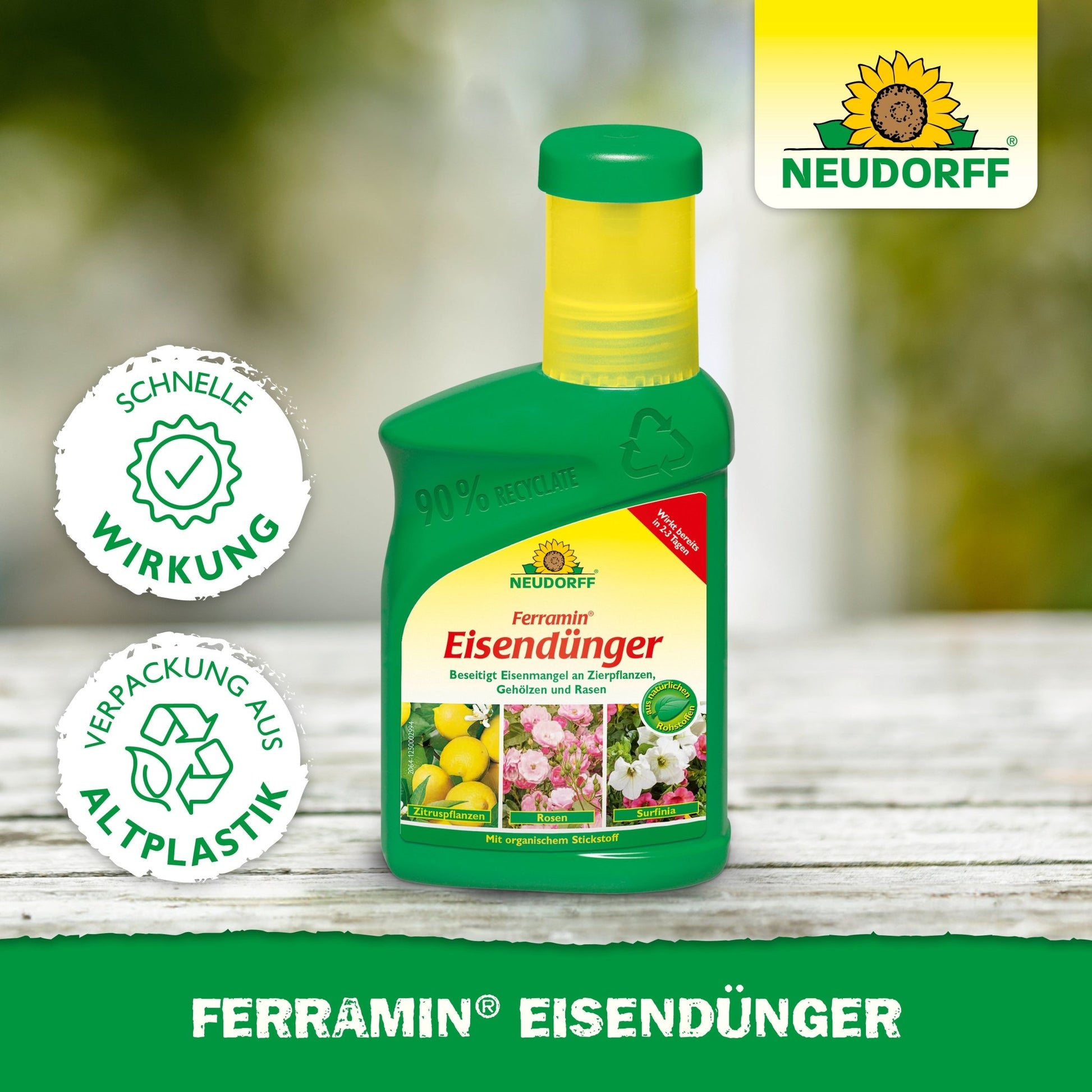 A green plastic bottle with Ferramin iron fertilizer from Neudorff Shop stands on a wooden surface. The label features flowers and lemons, advertising quick action against nitrogen deficiency and noting that it is packaged in recycled plastic.