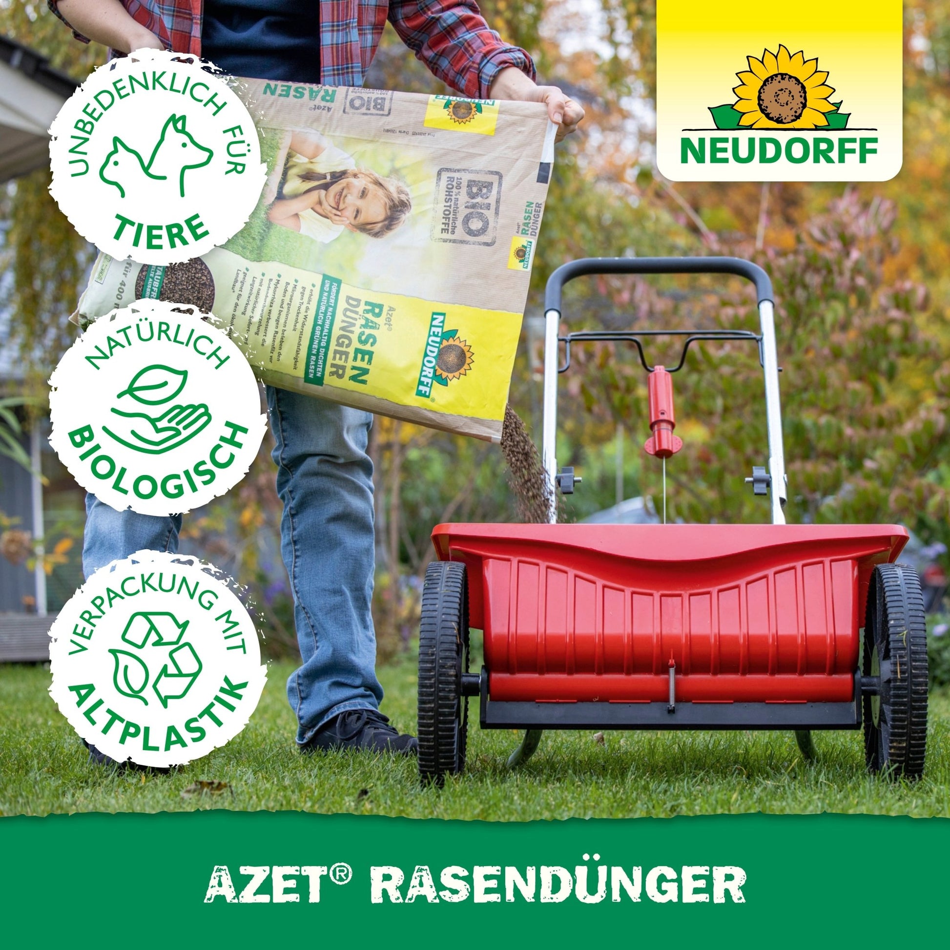 A person fills a red spreader with Neudorff Shop Azet Lawn Fertilizer 2.5-5 kg to promote dense lawn areas. Three symbols indicate it is pet-friendly, biologically natural, and made from recycled plastic. The Neudorff logo is visible.