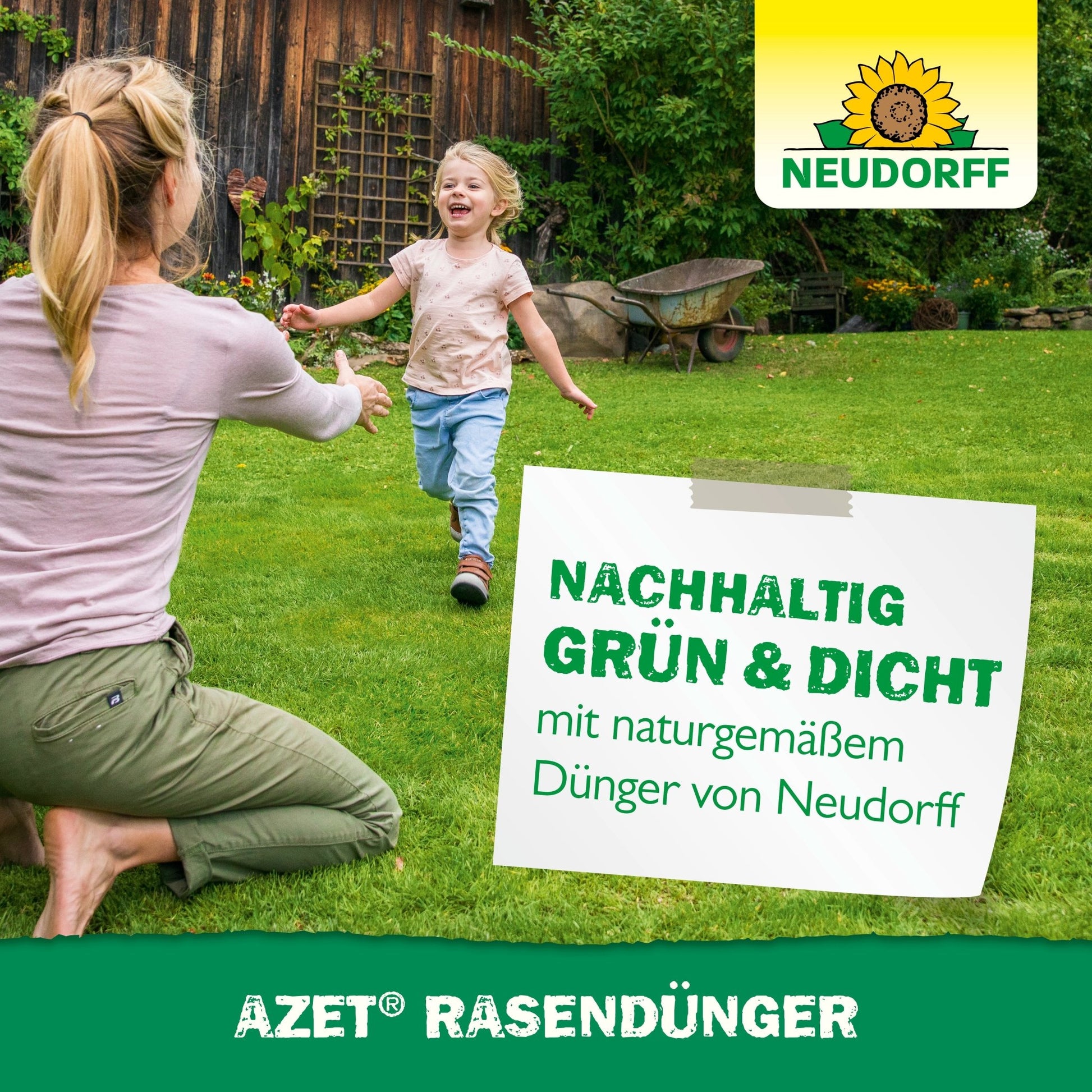 An adult and a child play on a green lawn in front of a wooden house. The Azet Lawn Fertilizer 2.5 kg to 5 kg from Neudorff Shop ensures a dense, resilient lawn - sustainably green and healthy with natural fertilizer.