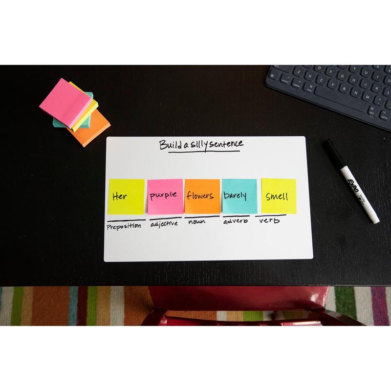 A Post-it® Notes cube from 3M Deutschland GmbH (76x76mm, 450 sheets, 100% PEFC) shows a sentence structure task on a whiteboard with grammar labels; additional sticky notes, a marker, a keyboard, and a striped carpet are nearby.