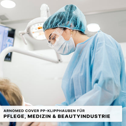 Ein Mitarbeiter des Gesundheitswesens in blauer PSA untersucht einen Patienten, in dessen Nähe sich medizinische Geräte befinden. Der Text wirbt für die ARNOMED COVER PP-KLIPPHAUBE XL (55cm, PP-Vlies) der ARNOWA GmbH - die ideale Einweg-Klipphaube für die Pflege-, Medizin- und Kosmetikbranche.