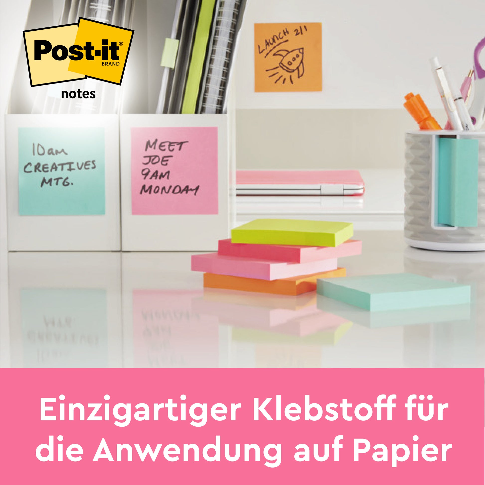 Ein aufgeräumter Schreibtisch mit 3M Deutschland GmbH Post-it® Notes in rosa (76x76 mm, 100 Blatt, 100% PEFC). Auf den Zetteln steht "10 Uhr CREATIVES MTG." und "MEET JOE 9 Uhr MONTAG." Deutscher Text: "Einzigartiger Klebstoff für Papieranwendungen.