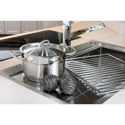 A stainless steel pot with a lid sits in the sink next to two Scotch-Brite® stainless steel spirals (3M Deutschland GmbH, 3 per package) and a dish rack—for easy kitchen cleaning, even with stubborn grime.