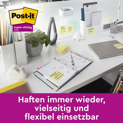On a tidy office desk are a planner, stationery, plant, laptop, and Post-it® Super Sticky 100% Recycled Notes (47.6 x 47.6 mm, 70 sheets/block, 100% PEFC) from 3M Deutschland GmbH. "Stick again and again, versatile and flexible use.