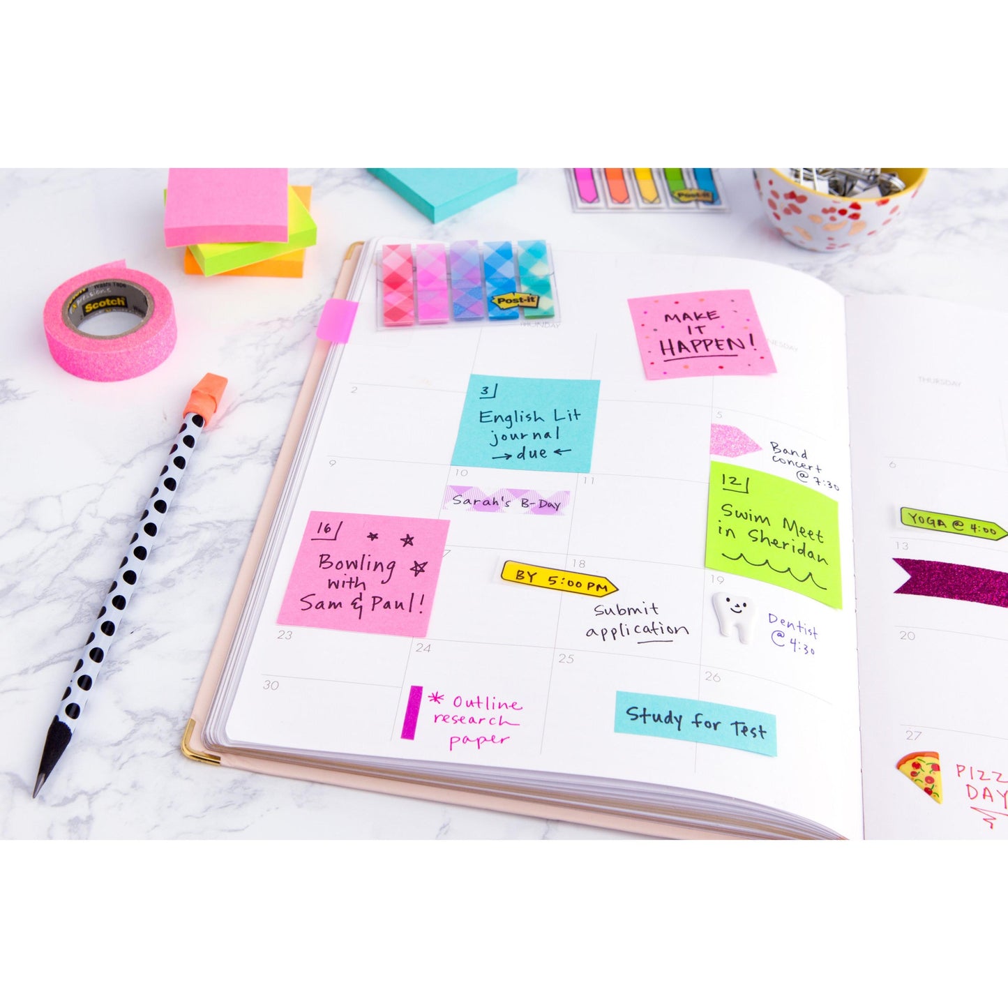 Ein offener Planer auf einer Marmorfläche zeigt handschriftliche Notizen mit bunten 3M Deutschland GmbH Post-it® Notes Würfel, Ultra-Farben (76 mm x 76 mm, 450 Blatt, PEFC zertifiziert), dazu Washi-Tape, einen Tupfenstift und Büroklammern.