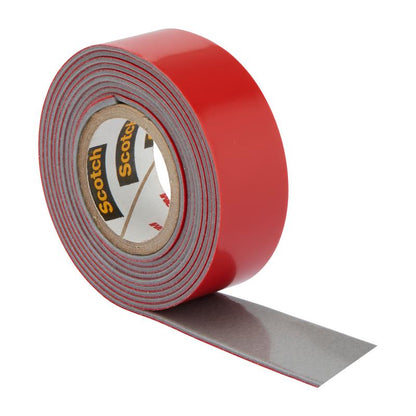 A roll of 3M Deutschland GmbH Scotch-FIX™ Extreme double-sided outdoor mounting tape with a red outer layer and gray adhesive side is partially unrolled and shown against a white background.