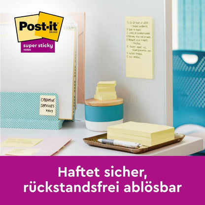 On a desk lie Post-it® Super Sticky 100% Recycled Notes (47.6 x 47.6 mm, 70 sheets/block, 100% PEFC) from 3M Deutschland GmbH, with a pen, folders, and a note on the divider. The logo appears; the German text reads: "Sticks securely, removable without residue."