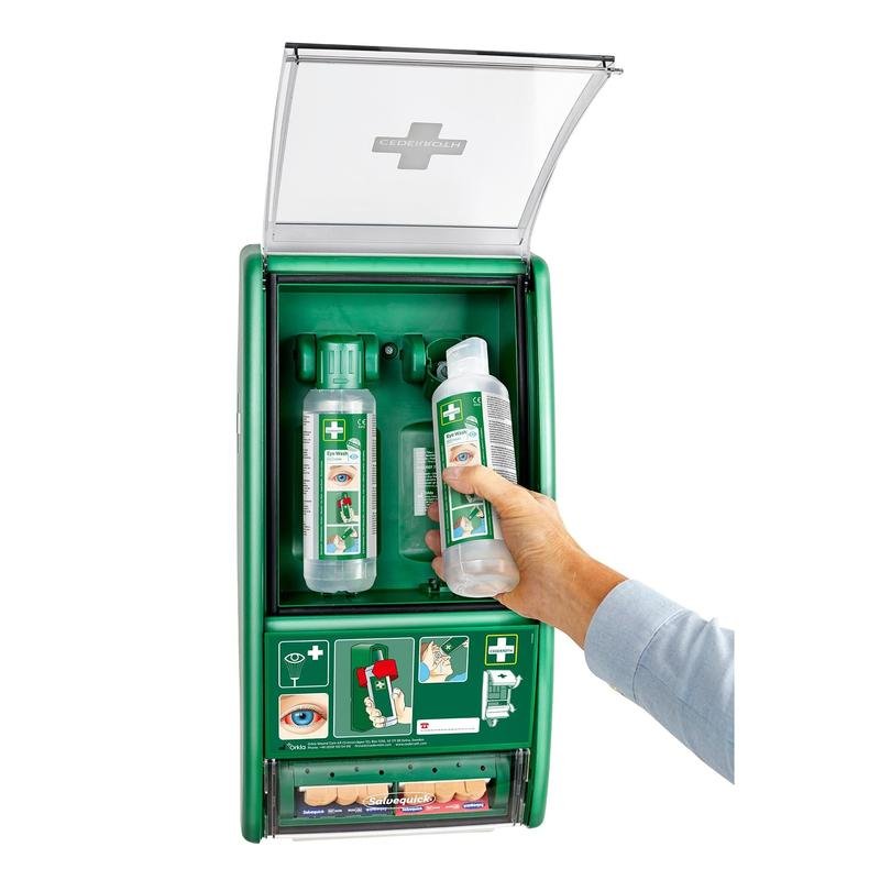 A hand removes a bottle from the Orkla Wound Care AB Cederroth eye wash station (incl. 2 x 500 ml bottles à 725200, with Salvequick plaster dispenser Ref 490700), ideal for eye wash emergency situations.