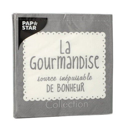 A gray PAPSTAR The GmbH 20-napkin pack (33x33 cm, 3-ply, 1/4-fold) features a white lace border, the French text "La Gourmandise source inépuisable de bonheur," and the PAP*STAR logo in white on black in the upper left corner.