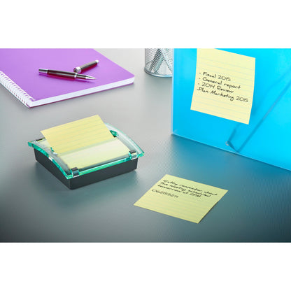 Auf einem Tisch liegen ein lila Notizbuch, zwei Stifte, ein Netzstifthalter, eine blaue Mappe mit Notizzettel XL und der 3M Deutschland GmbH Post-it® Z-Notes Dispenser XL mit Super Sticky Z-Notes im großen gelben linierten Format (101x101 mm).