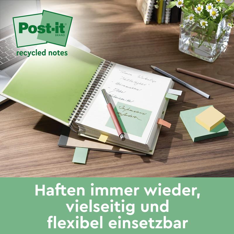 A desk with an open notebook with green Post-it® Recycling Notes (76 mm x 127 mm, 100 sheets/block, 100% PEFC) from 3M Deutschland GmbH, a pen, various colored Post-it® notes, a keyboard, a glass vase with plants, and German text at the bottom.