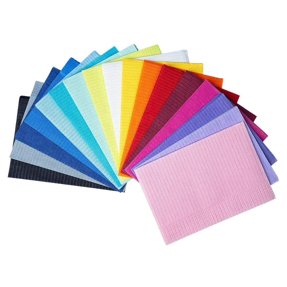 A selection of colorful AMPri Dental disposable patient napkins in various colors such as blue, green, yellow, orange, red, purple, and pink from the brand AMPri Handelsgesellschaft mbH. The napkins are elegantly fan-shaped on a white background.