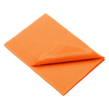 An orange towel, similar to the AMPri Dental disposable patient napkins from AMPri Handelsgesellschaft mbH, is neatly folded against a white background. Its texture is distinctly visible with vertical and horizontal grooves. One corner is slightly raised, showing the woven pattern on both sides.