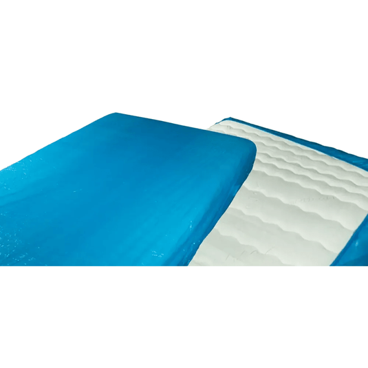 Close-up of a blue-and-white gel mattress topper that resembles the AMPri MED-COMFORT PE disposable mattress protector with elastic bands (210 x 90 x 20 cm) from AMPri Handelsgesellschaft mbH. The blue portion covers most of the upper surface, while the white portion has a wavy texture. The image shows a section folded back, similar to polyethylene hospital mattress covers.