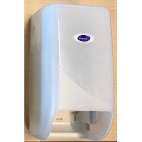 Der DI Systemrollenspender für Toilettenpapier von Diversey Deutschland GmbH & Co. OHG ist ein weißer, wandmontierter Spender mit transluzenter Frontabdeckung und ovalem Etikett, abgebildet vor einem hellen Holzhintergrund.