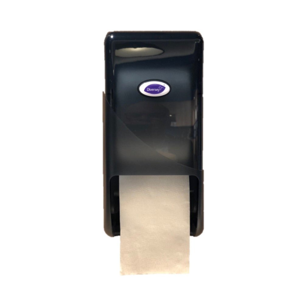 Ein schwarzer Kunststoff DI Systemrollenspender für Toilettenpapier von Diversey Deutschland GmbH & Co. OHG, wandmontiert mit sichtbarem, darunter hängendem weißem Papier und einem ovalen "Diversey"-Logo auf der Vorderseite, ideal für öffentliche Toiletten.