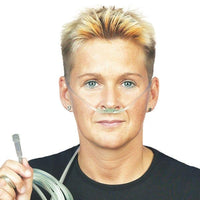 A person with short hair is using the DCT Soft oxygen goggles for adults, manufactured by Servoprax GmbH, for oxygen support. The person is holding the O2 connecting tube and is wearing a black shirt against a plain white background.