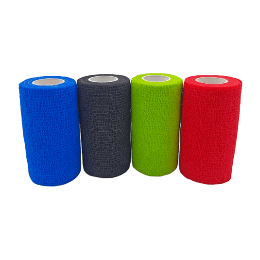 Vier Rollen Holthaus VliVet® Selbsthaftende Bandage für den Veterinärbereich von Holthaus Medical GmbH & Co. KG sind nebeneinander aufgereiht. Von links nach rechts sind die Farben blau, schwarz, grün und rot. Die Bandagen haben eine strukturierte Oberfläche und eine zylindrische Form mit einem weißen Innenkern, ideal für die Klauenpflege im Veterinärbereich.