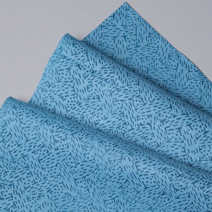 A close-up of the blue Kimtech® process wipes large roll from Kimberly-Clark GmbH, showing a geometric pattern. A roll with 500 sheets lies on a smooth, light gray surface - ideal for industrial cleaning.