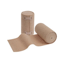 Ausgestellt sind zwei Rollen der Meditrade ABE Ven® kräftig dauerelastische Langzugbinde; eine aufrecht stehend und eine teilweise abgerollt, so dass die Textur sichtbar ist. Auf der aufrecht stehenden Rolle sind Metallklammern zur Fixierung der Binde zu sehen, die eine optimale Passform bei Venen- und Lympherkrankungen gewährleisten.