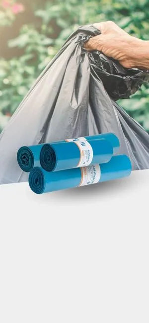 Müllsäcke und Abfallsäcke auf Rollen mit Hand, die einen gefüllten Müllbeutel hält, vor grünem Hintergrund.