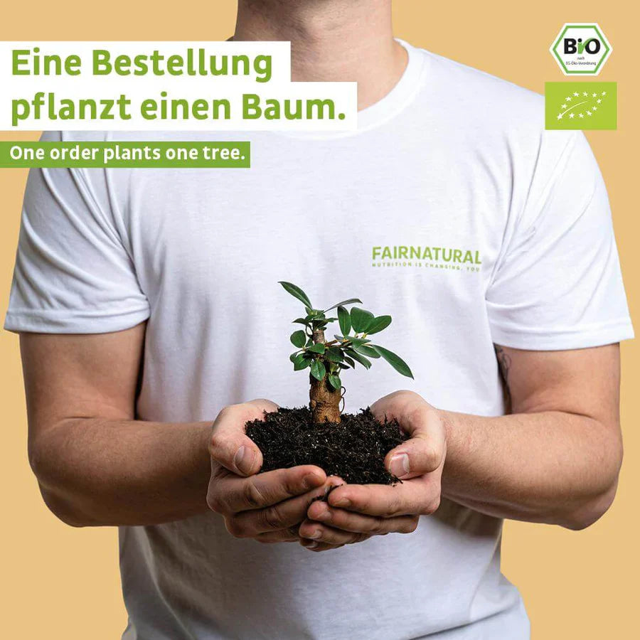 Eine Person in einem weißen Fairnatural®-Shirt hält eine kleine Pflanze, die Nachhaltigkeit symbolisiert. Mit jeder Bestellung - wie unserem Bio Veganes Proteinpulver Kokos ohne Soja - pflanzen wir einen Baum. Die Logos der Bio- und Öko-Zertifizierung sind sichtbar.