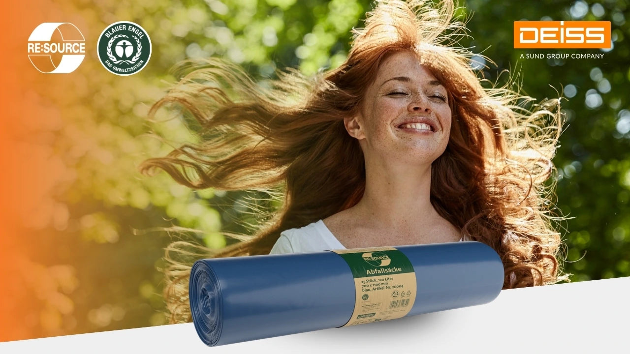 Fröhliche Frau mit langen, im Wind wehenden roten Haaren steht in einer grünen, sonnigen Naturkulisse und lächelt mit geschlossenen Augen. Im Vordergrund liegt eine Rolle blauer Müllsäcke mit „RE:SOURCE“-Label. Oben links sind die Logos „RE:SOURCE“ und „Blauer Engel“, oben rechts das Logo „DEISS – A SUND GROUP COMPANY“.