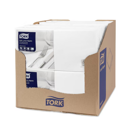A carton contains several packs of Tork 477414 Soft Lunch Napkins, with each pack bearing the TORK logo and product information. The napkins, 3-ply for longer durability, are neatly stacked in the partially open box.