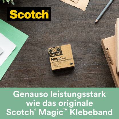 Der Scotch® C38 Tischabroller schwarz mit 3 Rollen Scotch® Magic™ Klebeband (19 mm x 33 m, 66 % pflanzlicher Klebstoff) von 3M Deutschland GmbH liegt auf einer Holzoberfläche neben Papier, Stift und Karton.