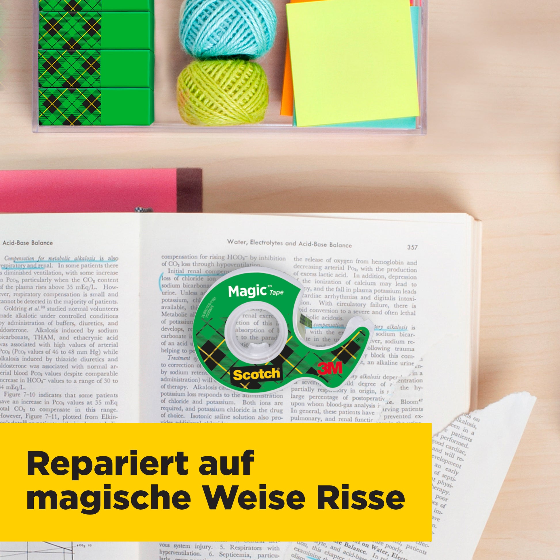 Eine Rolle Scotch® Magic™ Unsichtbares Klebeband von 3M liegt auf einem offenen Buch, umgeben von bunten Haftnotizen, Garn und einem Handabroller. Eine gelbe Bannzeile unten zeigt: "Repariert auf magische Weise Risse.