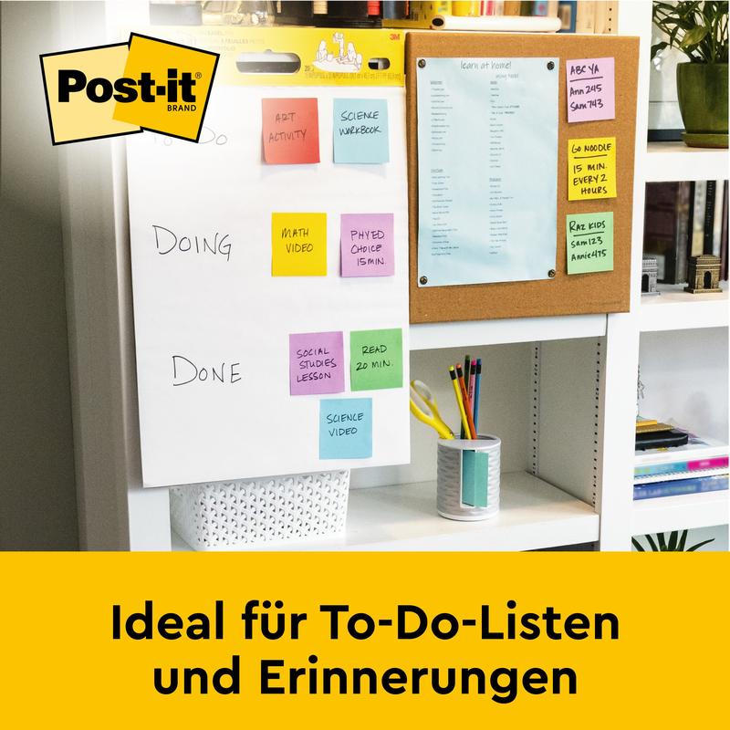Auf dem Schreibtisch steht ein Post-it® Super Sticky selbsthaftendes Meeting Chart/Flipchart von 3M Deutschland GmbH (weiß, 63,5x76,2cm), perfekt für To-Do-Listen & Erinnerungen. Im Hintergrund: eine Pinnwand mit blauem Papier.