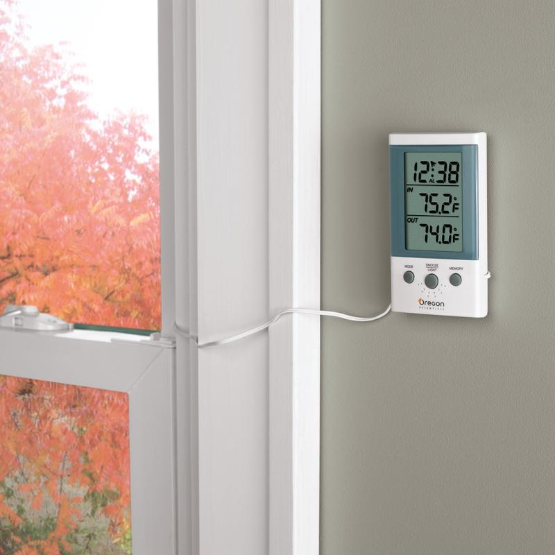 A digital thermometer displaying indoor and outdoor temperatures is mounted with the 3M Germany GmbH Scotch-FIX™ Double-Sided Indoor Mounting Squares 4496-ST16-P (25 mm x 25 mm, 16 pieces/package) near a window with red autumn leaves on the wall.