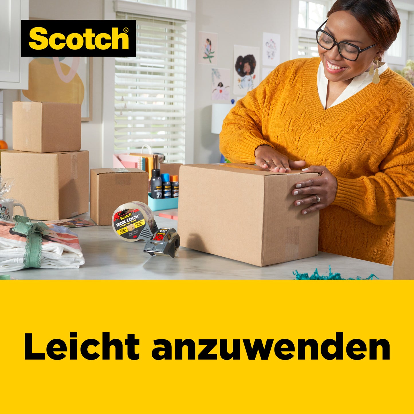 Eine Person mit Brille und gelbem Pullover verwendet das 3M Deutschland GmbH Scotch® Box Lock™ Verpackungsklebeband 3950-LR3-DC (48 mm x 50 m, 3 Rollen/Packung), um einen Karton in einem hellen, aufgeräumten Raum mit einer Kartonverpackung zu verschließen; der Text lautet "Leicht anzuwenden".