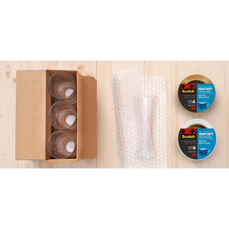 Vier Glasbecher in einem Karton, Luftpolsterfolie und zwei Rollen Scotch® Extra starkes Verpackungsklebeband (3M Deutschland GmbH, transparent, 48 mm x 20 m) werden auf einer hellen Holzfläche angeordnet.