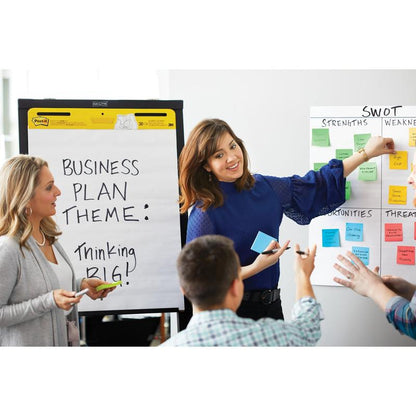Four people meet in a room. A woman points to a Post-it® Super Sticky Z-Note (76x76 mm, 3M Deutschland GmbH) on a SWOT diagram. Another stands next to a flipchart with the inscription "Business Plan Theme: Thinking Big!".