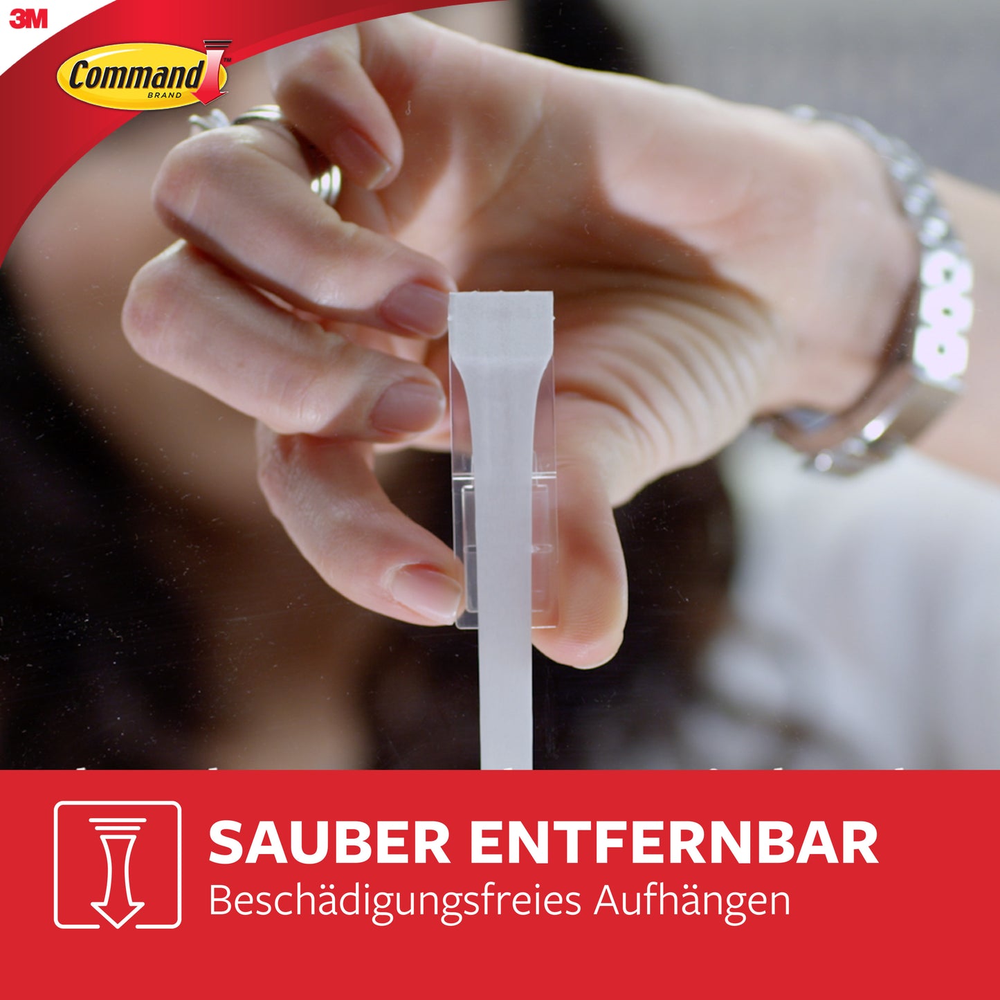 Eine Hand entfernt einen weißen Multipack Command™ Strip, 17200 von 3M Deutschland GmbH von einer klaren Oberfläche. Das Bild zeigt das 3M Command-Logo mit deutschem Text: "Sauber entfernbar. Beschädigungsfreies Aufhängen.